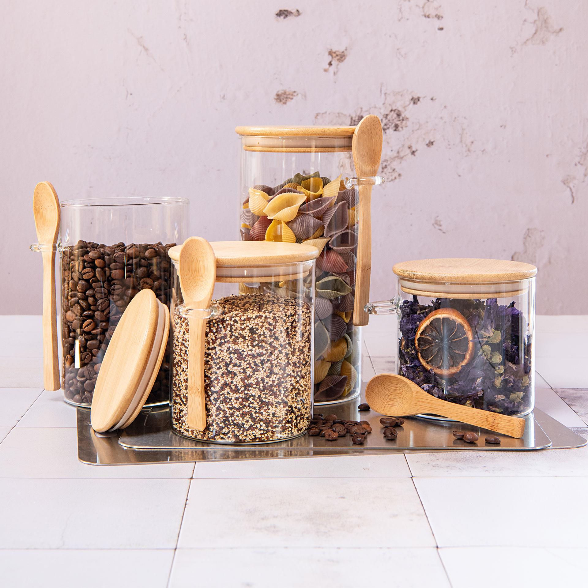 Vier Vorratsgläser aus Glas mit Bambusdeckel und passenden Löffeln, befüllt mit Müsli, ideal zur Aufbewahrung von trockenen Lebensmitteln wie Zucker, Reis oder Getreide