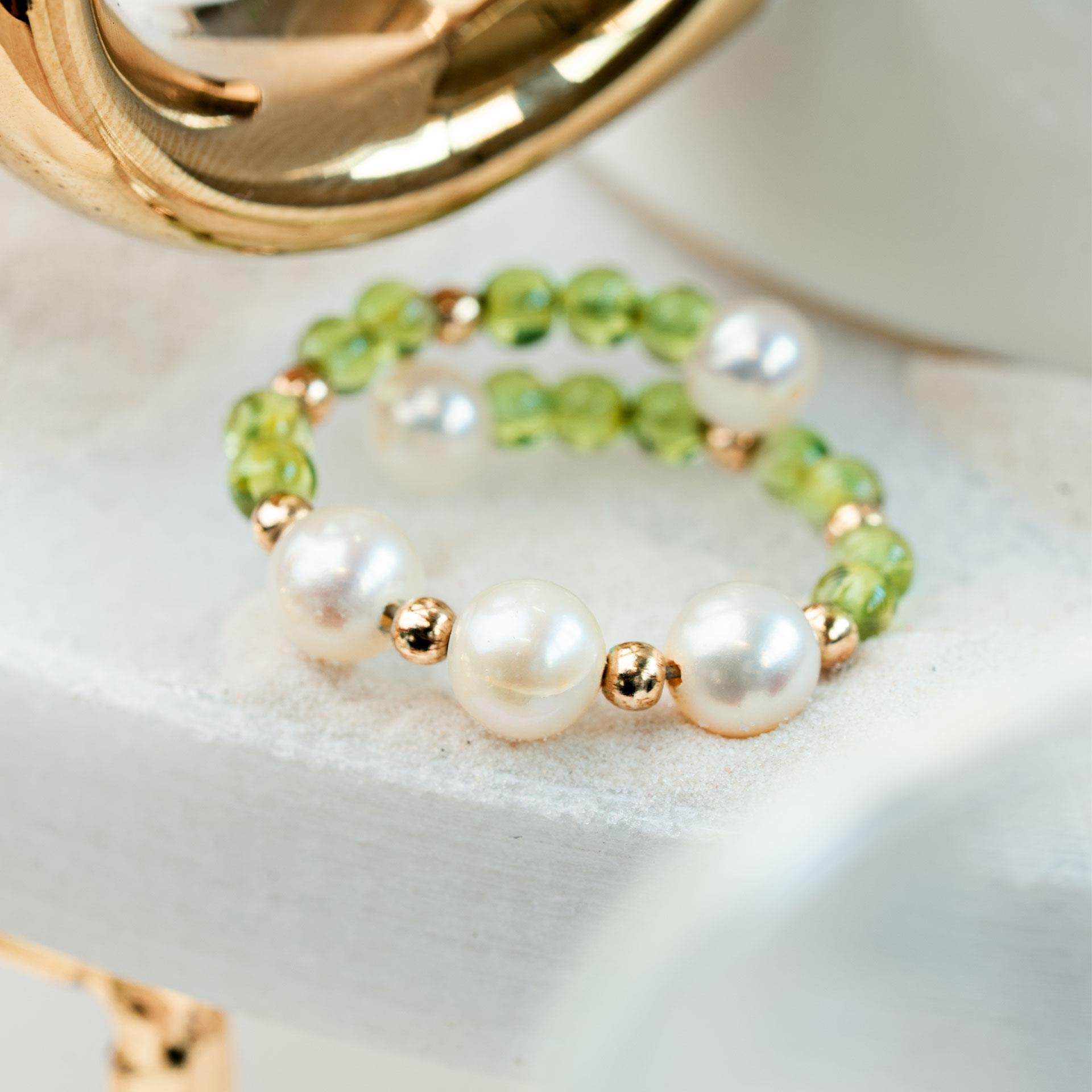 Fingerring aus weissen Perlen mit grünen Peridotsteinen
