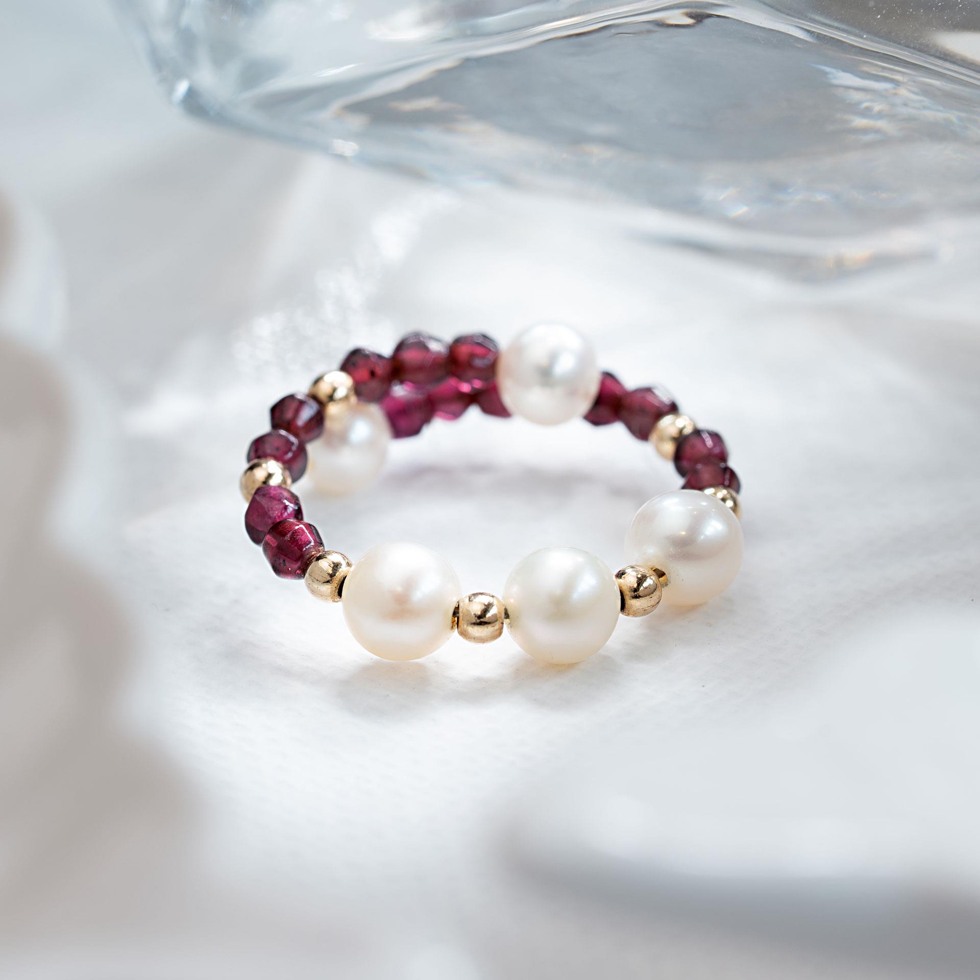 Fingerring aus weissen Perlen und Granatsteinen