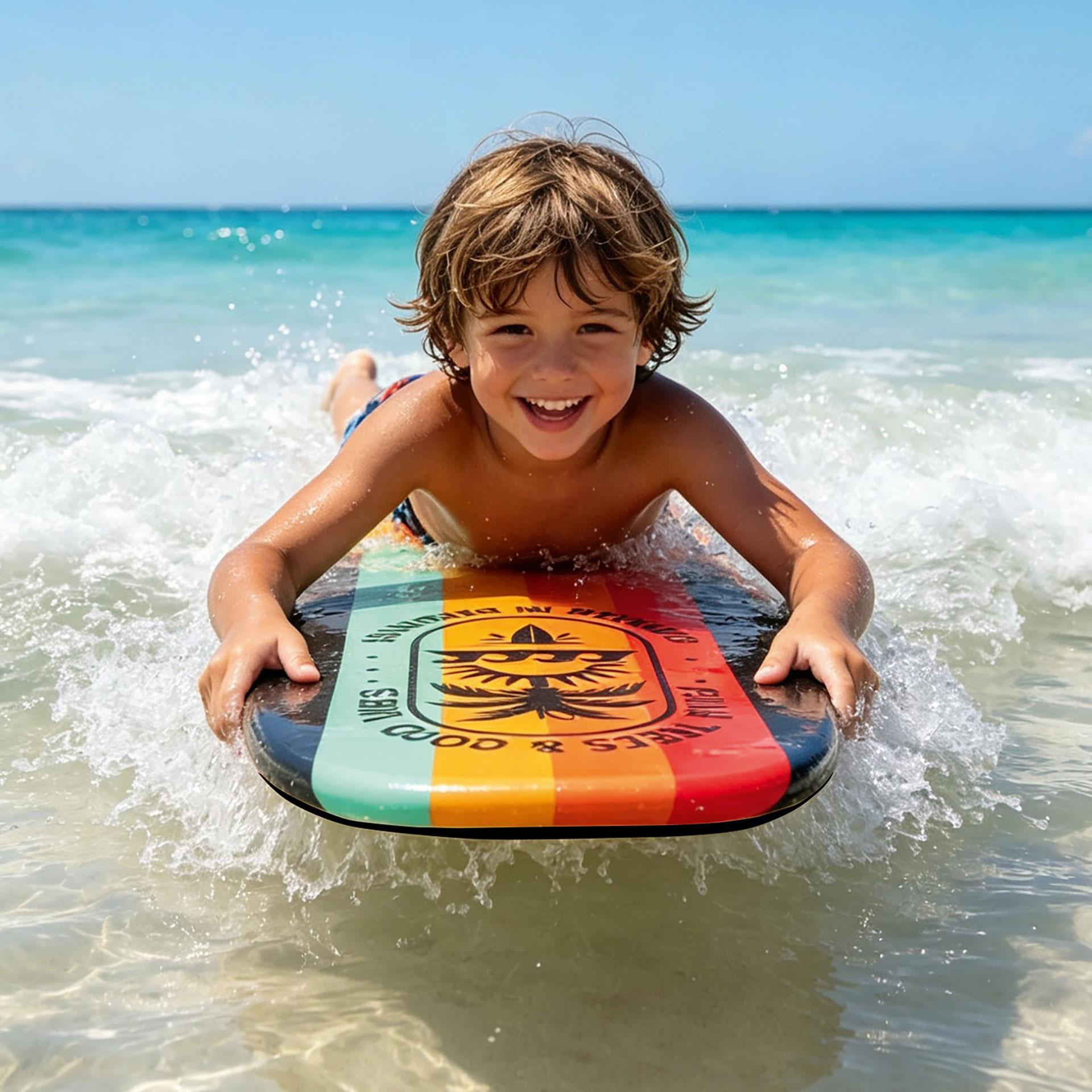Das Bild zeigt Kind im Meer, das auf buntem Bodyboard in flachen Wellen liegt