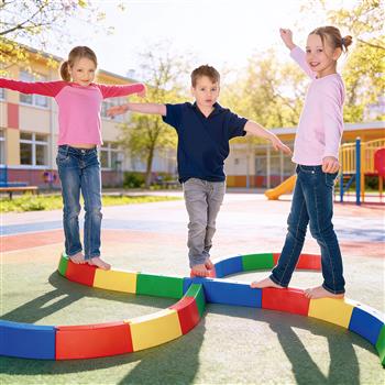 Ein Kind balanciert im Garten auf einem farbigen Balancierweg aus geraden und gebogenen Elementen, die zu einer Acht gelegt sind